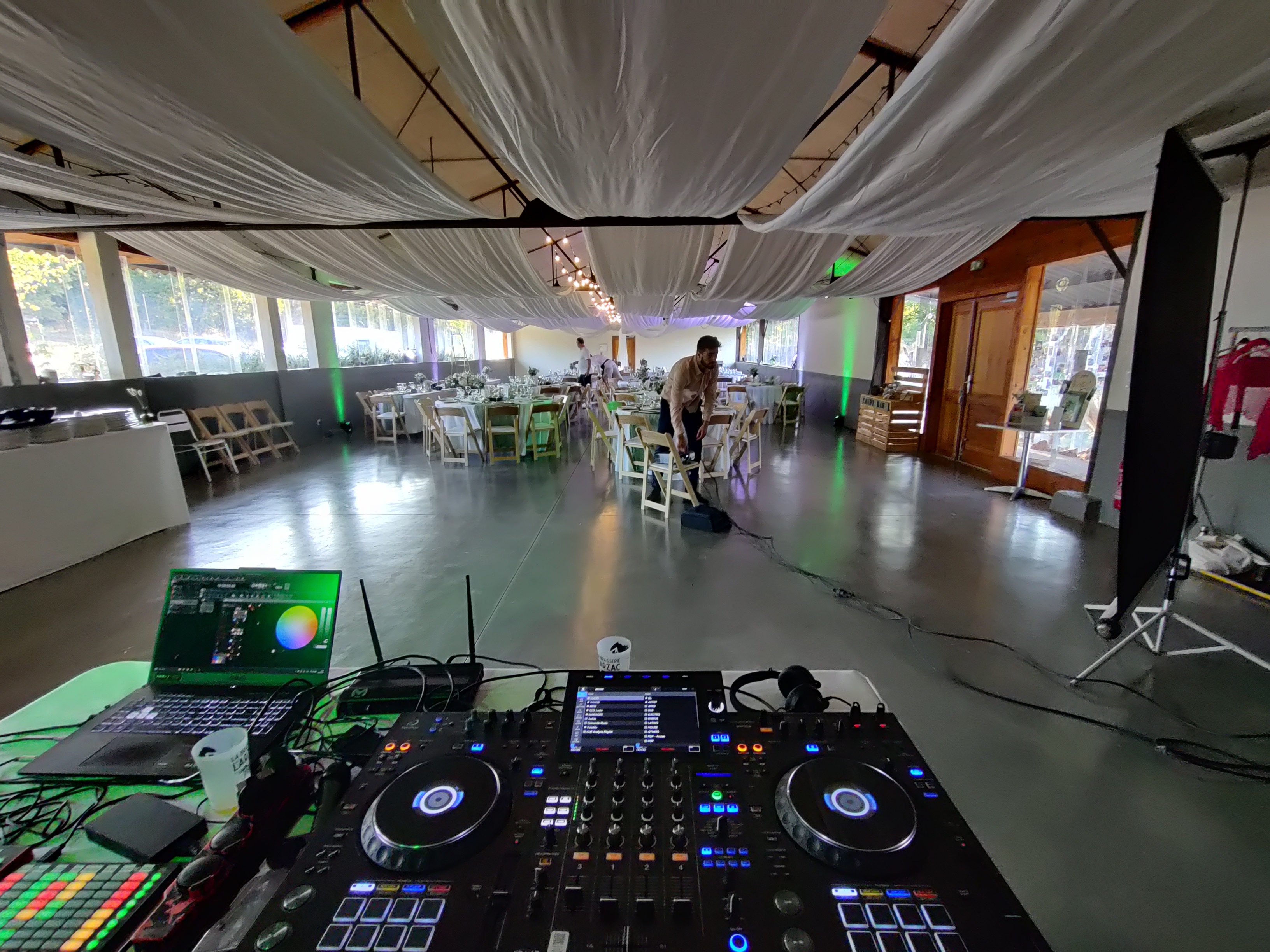 Photo de salle de mariage depuis le DJ avec table de mixage et projecteur pour l'animation
